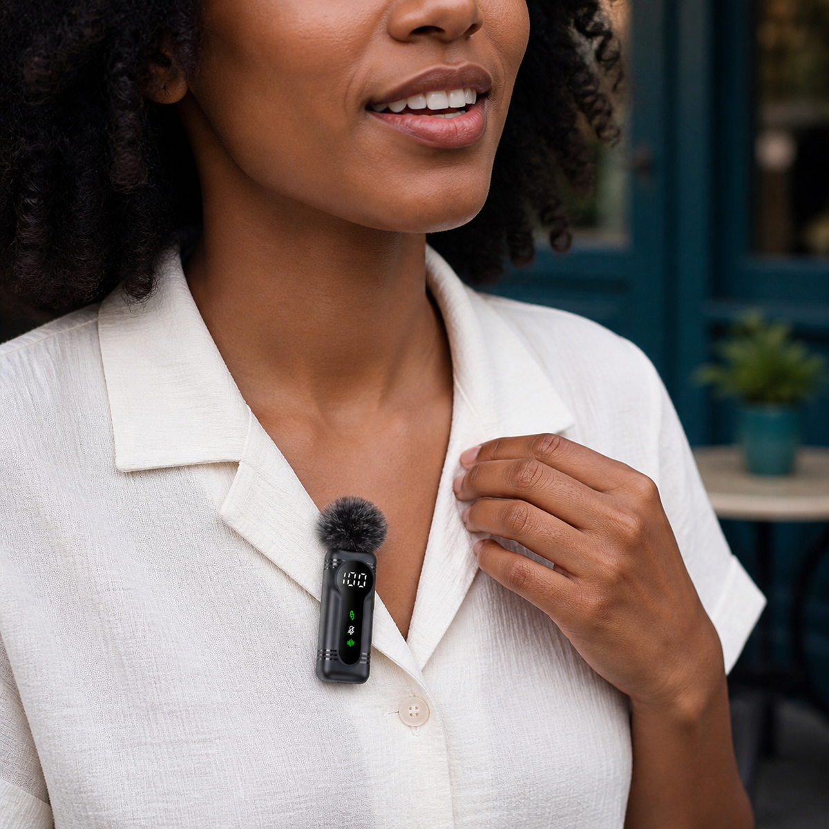 Wireless microphone with a furry windscreen clipped to a creator’s shirt